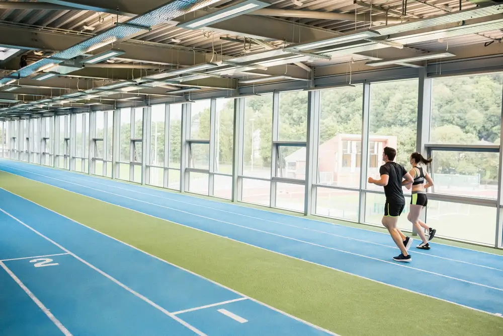 Candidats militaires en tenue de sport alignés pour passer le test Luc Léger sur une piste intérieure