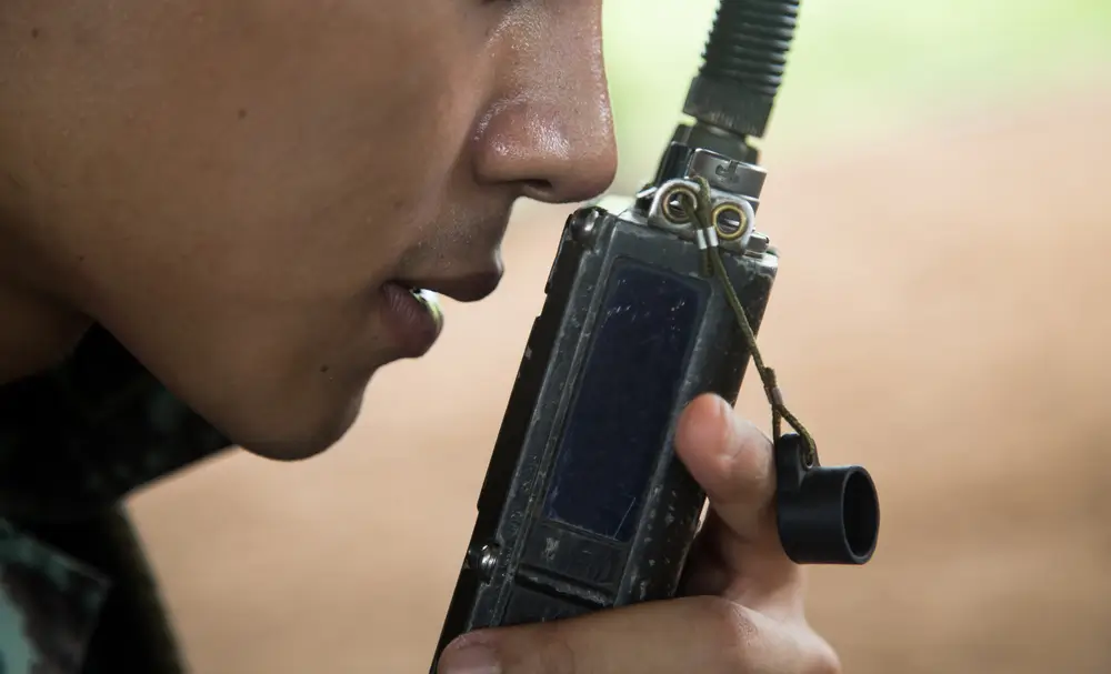 Soldats en opération utilisant des radios portatives pour transmettre des coordonnées sur le terrain