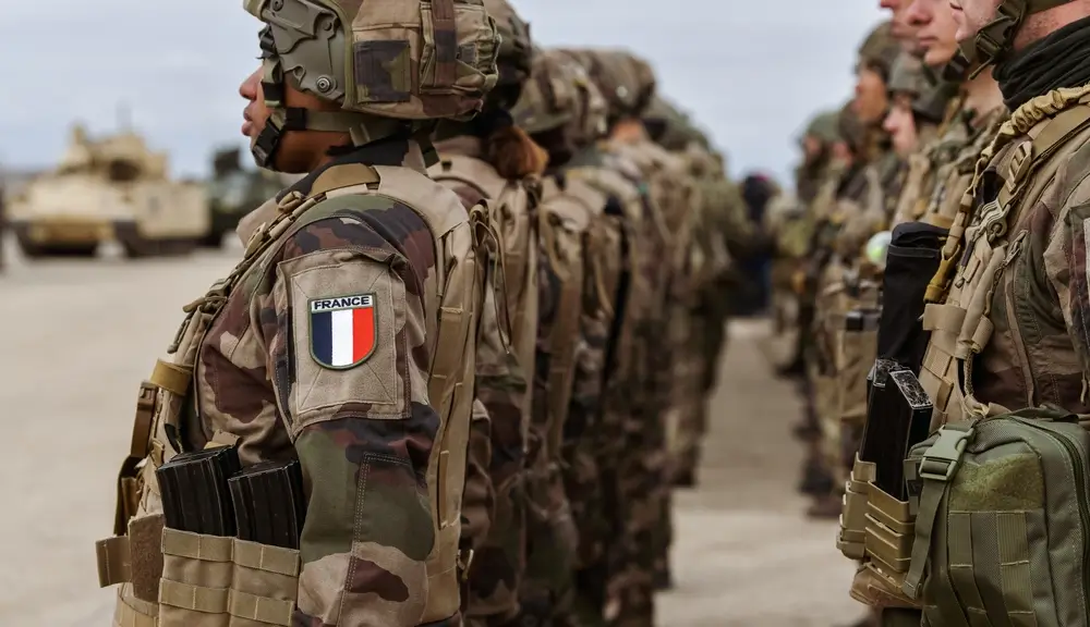 Soldats de l'armée de terre française alignés en formation militaire, écusson France visible sur l'uniforme de combat.