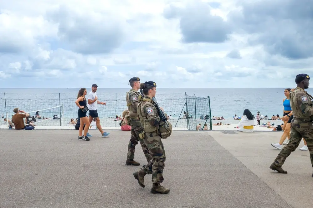 Soldats français en opération patrouillant sur une promenade littorale pour assurer la sécurité.