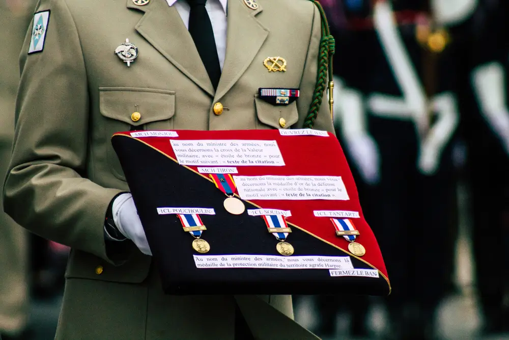 Officier militaire examinant des galons et insignes de grades sur une table