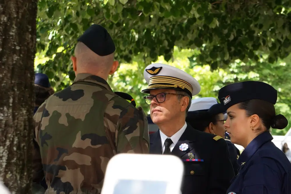 Officier décoré et militaires en uniforme assistant à une cérémonie de promotion militaire en extérieur.