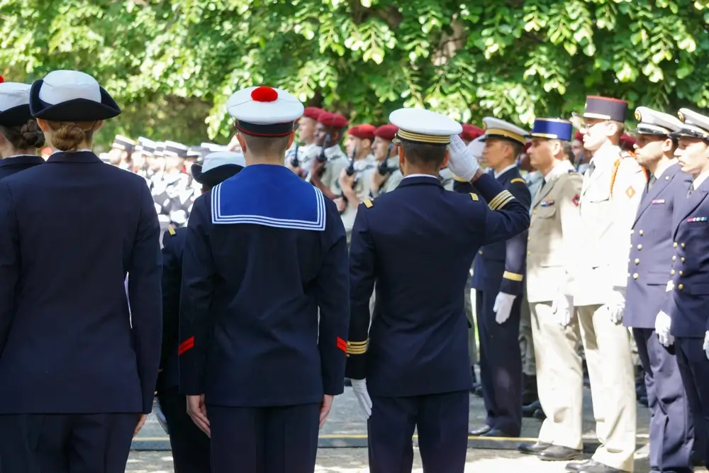 Élèves officiers en uniforme de cérémonie de différents corps d'armée lors d'un salut militaire solennel.