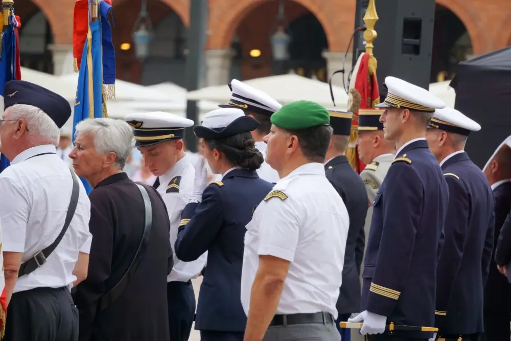Militaires en uniforme lors d'une prise d'armes devant le drapeau français, emblème d'honneur et de patriotisme.