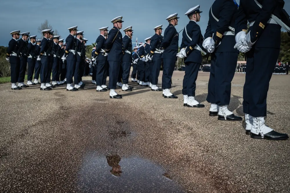 Militaires en uniforme alignés sur une place d'armes lors d'une séance d'entraînement et de préparation.