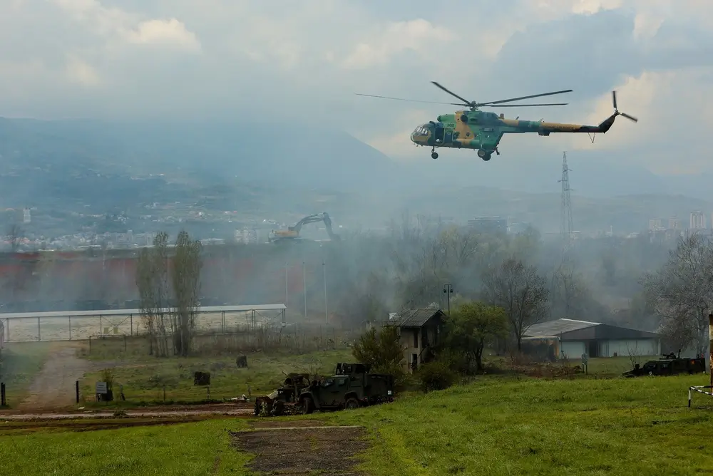 Hélicoptère militaire en vol de formation au-dessus d'un terrain d'entraînement de l'aviation de l'armée de terre.