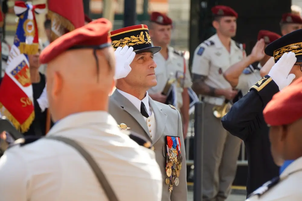 Officier militaire en uniforme de cérémonie effectuant un salut lors d'une cérémonie de remise de grade.
