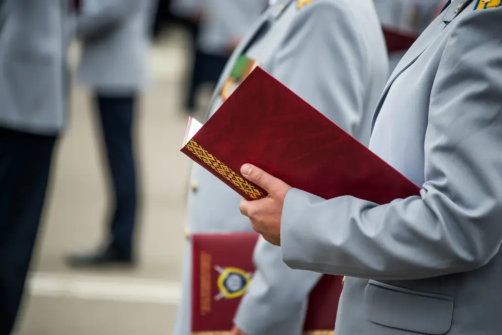 Militaires tenant un diplôme rouge lors d'une cérémonie, illustrant l'équivalence civile du BSTAT au niveau 5 RNCP.